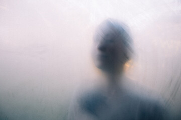 Woman portrait through a foggy glass in autumn