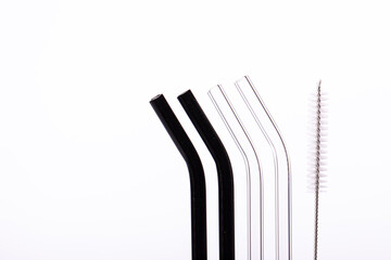Four transparent and black glass reusable beverage straws with cleaning brush isolated on white background. Zero waste concept. Eco-Friendly Drinking Straw Set with Cleaning Brushes