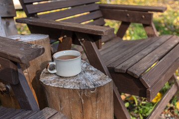 Cup with tea and wooden chairs, outdoors