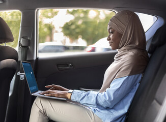 Black Muslim Businesswoman Using Laptop In Car While Going To Work