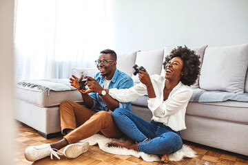 Did it! The best team ever. Beautiful lovers on a date indoors, they are playing video games. Their team have won, they are giving high five to celebrate. Smiling young couple playing video game
