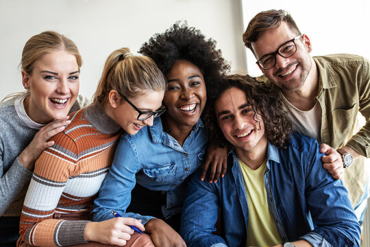 In the classroom, a group of college students gathers for a portrait, their faces reflecting excitement and camaraderie as they embark on their educational journey together.	