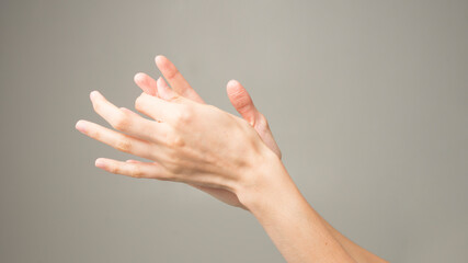 Close-up of female hands holding her painful wrist caused by prolonged work on a computer, laptop. Carpal tunnel syndrome, arthritis, neurological disease.