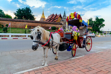 Naklejka na ściany i meble Horse carriage stand in front of Wat Phra That Lampang Luang, an ancient magnificent Lanna architecture in Lampang province, Thailand