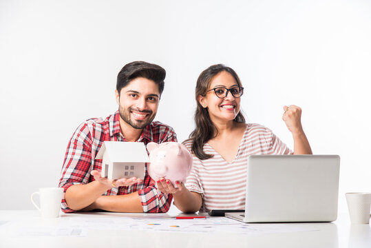 Indian Asian Young Couple Accounting, Calculating Bills, Planning Budget For Home Loan Using Laptop