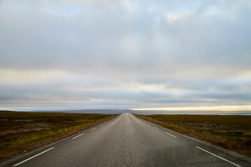 Fototapeta na wymiar Landscape with road in tundra in Norway at cloudy evening