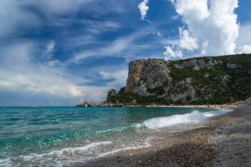 Fototapeta na wymiar sunny beach with clear water and famous rock formation. Cala Luna beach, Sardinia, Italy