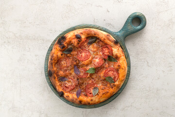 delicious pizza with tomatoes and basil on a wooden tray
