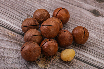 Brown macadamia nut heap over background