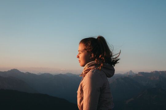 Woman Standing On Mountain Against Clear Sky During Sunrise