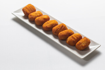 Fried Spanish ham Croquettes over a white background