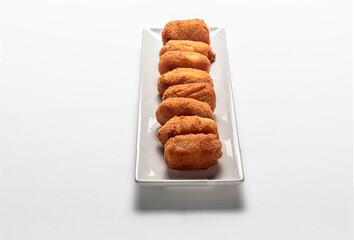 Fried Spanish ham Croquettes over a white background