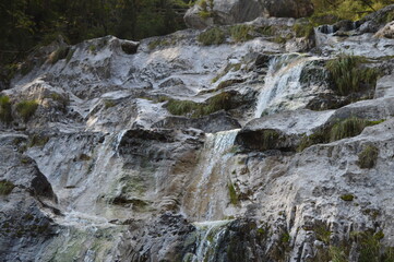 Fototapeta na wymiar Waterfall by the mountain rocks