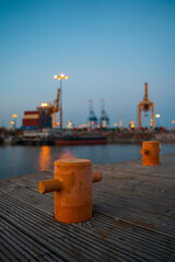 Bollard at harbor with water in the background