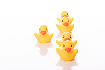 group of toy rubber ducks in formation with their leader isolated on white background. Minimal style. leadership concept. Get out of soldier's formation. Deserter. Desertion concept