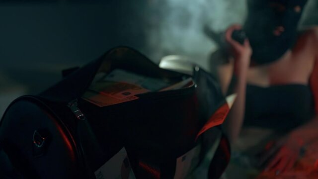 The girls robbers in a black masks and sexy suit with pistols and cash. Bag with money. Role-playing games