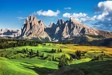 Famous Alpe di Siusi - Seiser Alm with Sassolungo - Langkofel mountain group in background at sunset. Wooden chalets in Dolomites, Trentino Alto Adige region, South Tyrol, Italy