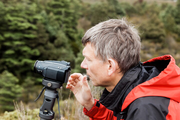 Mature man filming with camcorder