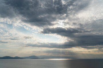 Sonnenstrahlen durchbechen Wolken bei Sonnenuntergang am Meer