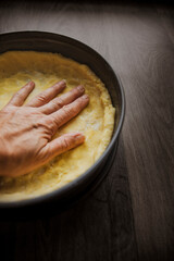 Nahaufnahme von Hand die Teig in Kuchenform knetet