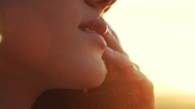 dream face of a beautiful girl lips hair fluttering in the wind in the sunlight dream of happiness. people in the park concept. model face lips strong wind hair swaying close-up in the park