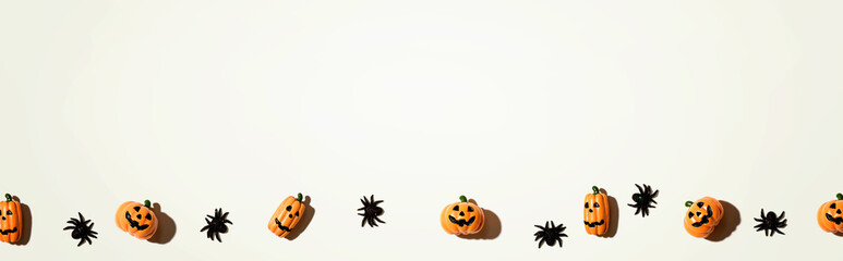Miniature Halloween pumpkin ghosts with spiders - flat lay