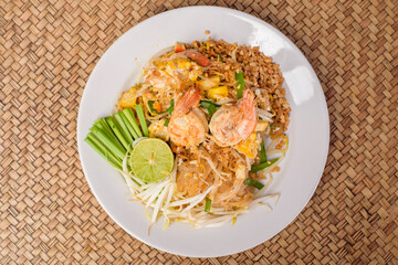 Top view of Thai traditional food  Pad Thai Noodles with shrimp in dish on wooden table
