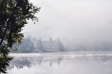 Fototapeta na wymiar Fog over a lake in the morning in Lipno Nad Vltavou, Czech Republic
