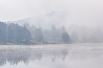 Obraz na płótnie Canvas Fog over a lake in the morning in Lipno Nad Vltavou, Czech Republic