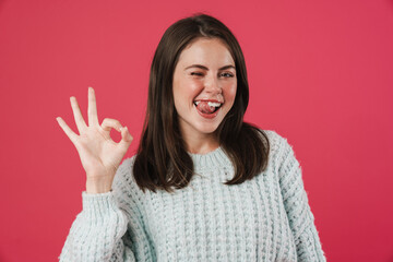 Image of funny beautiful girl showing ok gesture and winking