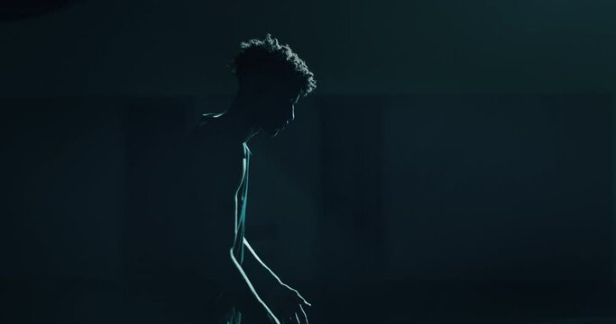 Cinematic slow motion shot of a professional young african man is practicing basketball work out in a gym. 