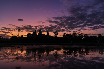 Naklejka premium The silhouette of Angkor Wat temple, reflected on the water surface at the entrance of the temple, Siem Reap, Cambodia.