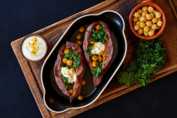  Baked sweet potato filled with kale and chickpeas . Top view with copy space