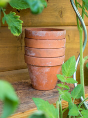 Stack of terra cotta pots on a wooden shelf