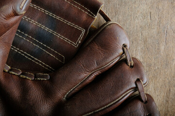 Old brown baseball glove leather close up.