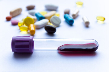 Test tube with blood on the background of pills. Health concept.