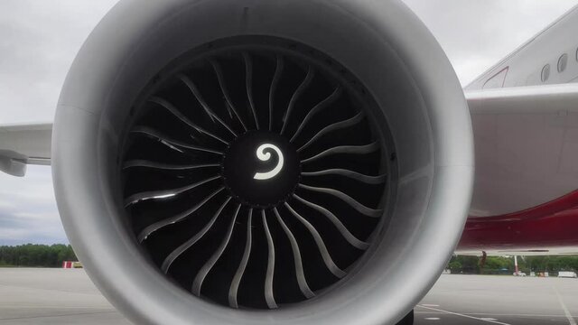 The engine of a jet plane is spinning in the wind, close-up.