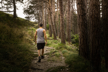 Fototapeta premium Young caucasian man exploring a foggy forest in Artikutza, Basque Country.