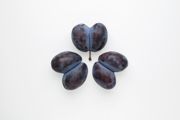 Ugly prunes. Three double plums fused together on a light background. Flat lay, top view, copy space. Concept - Food waste reduction. Using in cooking imperfect products