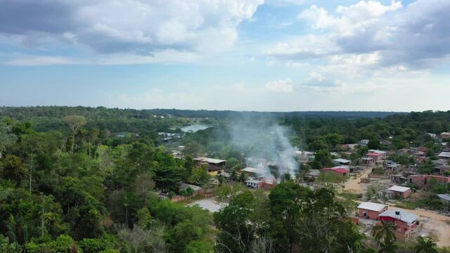 Aerial shot flying over an indigenous slum near Manaus, Brazill. Smoke rising from the houses.