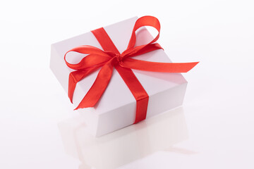 Beautiful white gift box with red bow isolated on white background. Presents, surprise, valentine's women's day greeting, holiday congratulations, store promotion, marriage proposal concept. Close up
