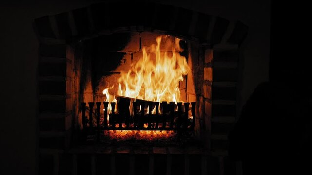 Burning Flame At Fireplace on wooden logs. Medium shot of a yule log burning in a fireplace.
