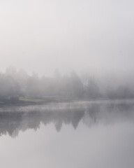 Fototapeta premium Fog over a lake in the morning in Lipno Nad Vltavou, Czech Republic
