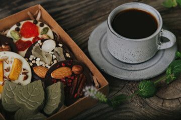 Chocolates with dried fruits in a craft box and a cup of espresso coffee.