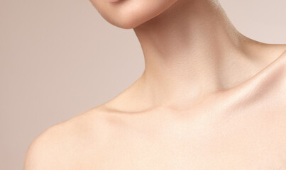 Asian women's neck and collarbone on a nude background - obrazy, fototapety, plakaty