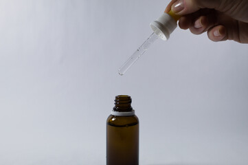 Dropper with glass ampoule with female hand holding