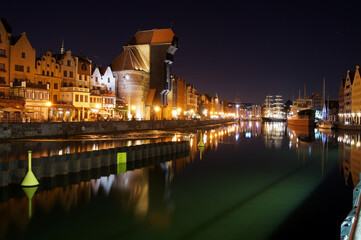 Fototapeta na wymiar Night panorama of Old Town's waterfront in Gdansk. Yachts moored at Motlawa river.