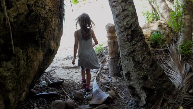 Young girl walks down path leading to beautiful beach on Isle of Pines. 50fps.