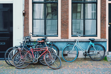 Fototapeta na wymiar Bicecles which are a very popular transport in Netherlands parked in street near old houses. Utrecht, Netherlands