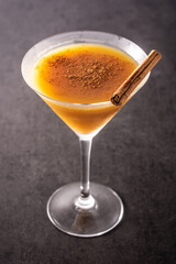 Pumpkin cocktail in glass on black stone